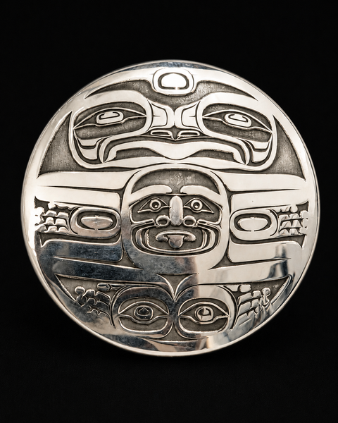 This sterling silver Frog Clan Moon pendant by Kolten Khasalus Grant features a finely carved Northwest Coast design in a compact sculptural format front.