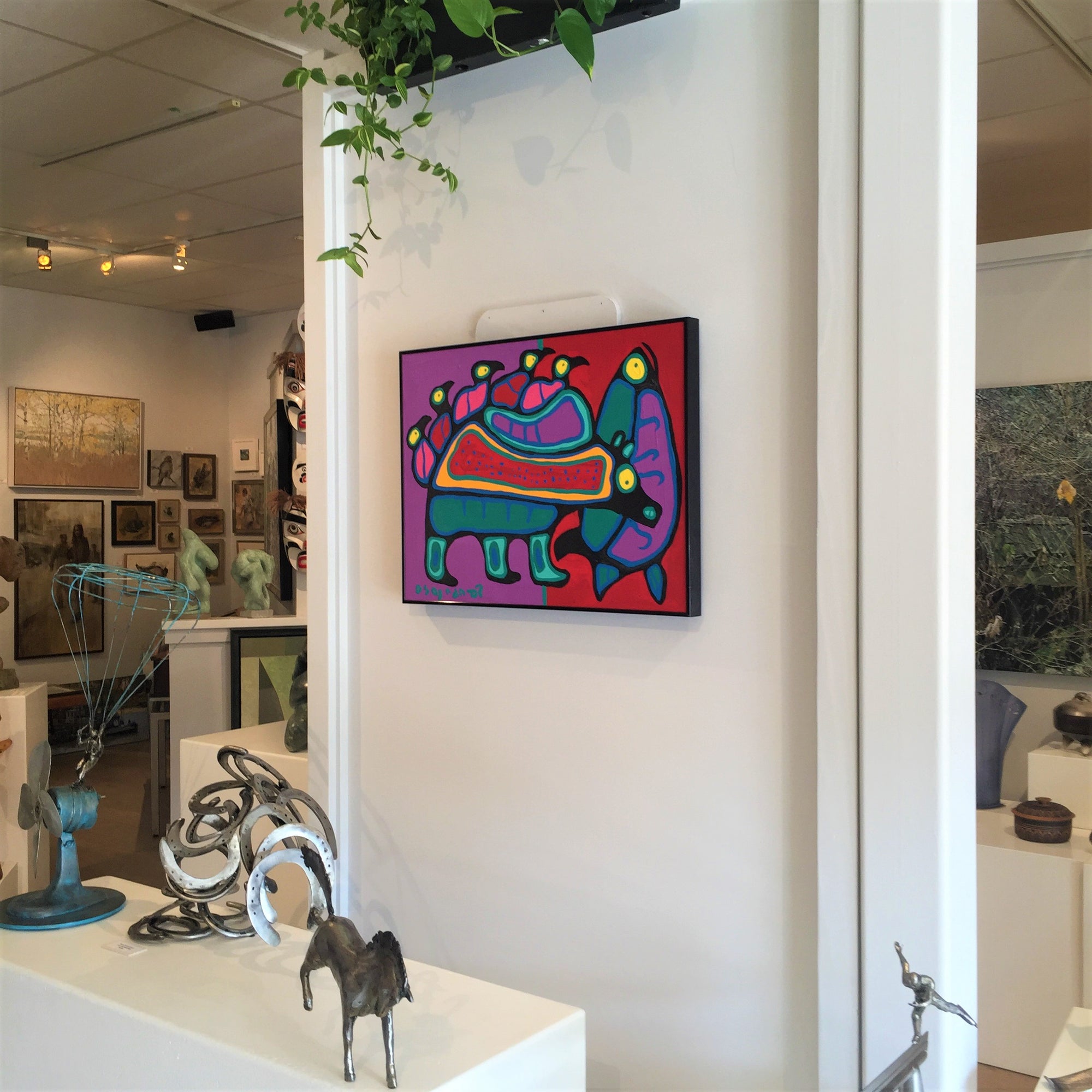 photograph of original painting by norval morrisseau at steffich fine art gallery on salt spring island with peter mcfarlane metal sculptures and gallery in background