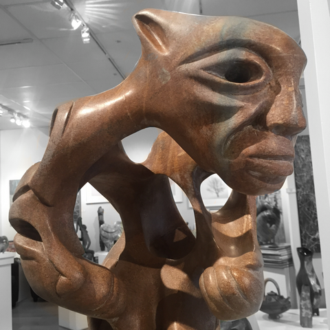 soap stone sculpture by abraham ruben of a shaman with intertwined helpers close up