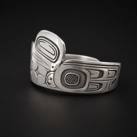 This sterling silver Hummingbird and the Flower People cuff bracelet by Kolten Khasalus Grant carries a flowing Northwest Coast design across a substantial wearable form other side.