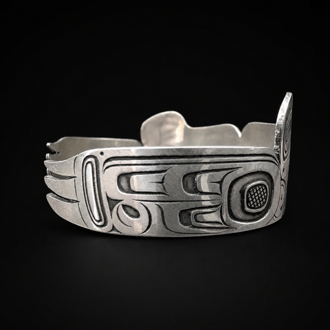 This sterling silver Hummingbird and the Flower People cuff bracelet by Kolten Khasalus Grant carries a flowing Northwest Coast design across a substantial wearable form side.