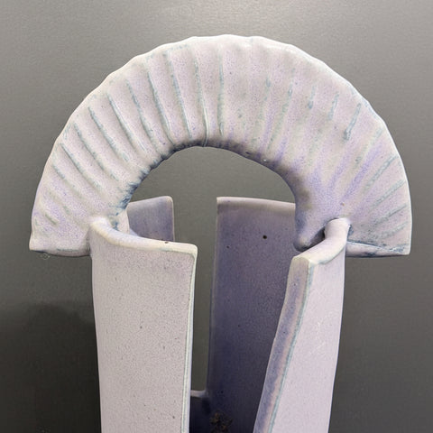 Close-up of a ceramic arch with textured surface on a gray background