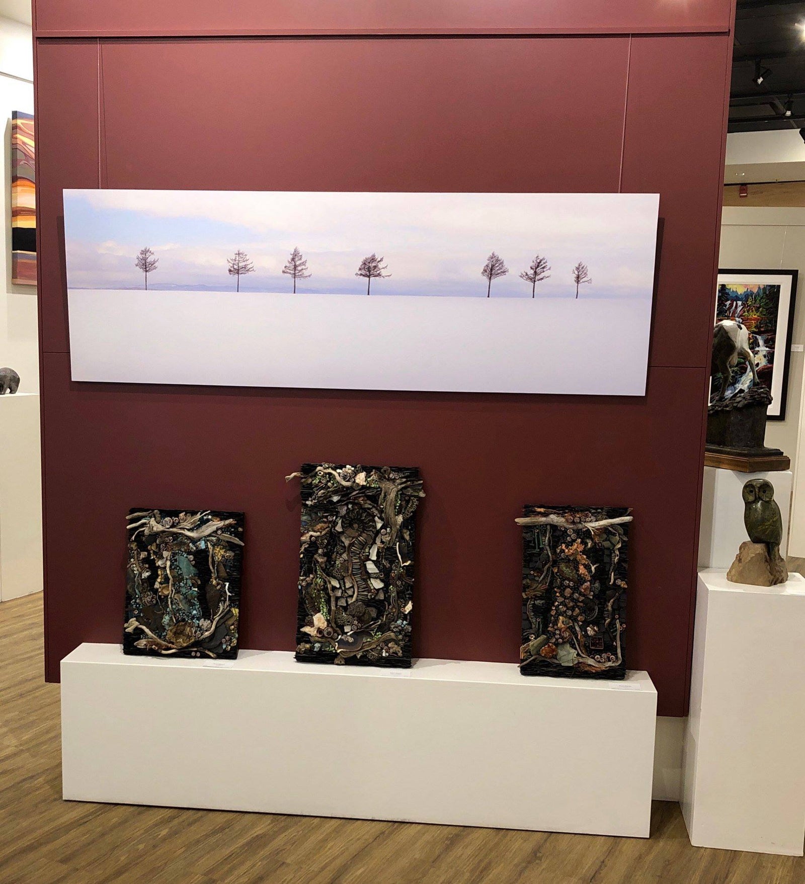 steven friedman's panoramic photograph hung above bed featuring seven trees spectacular soft sunset colours on snow scene in japan